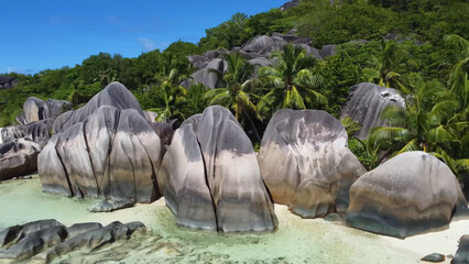 Luxury resort photo of Seychelles tropical paradise islands
in Indian Ocean with palm trees, sandy beach, stones.
Beautiful photography, coral reef, azure ocean, 
sky with clouds. 