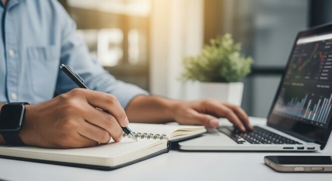 Writing alphabet letters in notepad with stock data on laptop screen. Writing alphabet at desk, with person taking notes in notebook and reviewing business graphs. - Powered by Adobe