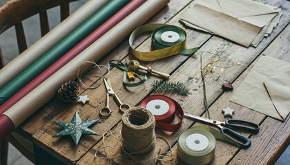 Holiday gift wrapping supplies on rustic wooden table