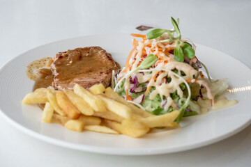 Close up of Grilled pork steak, boiled french fries and vegetable salad;Selective focus