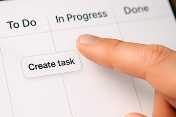 Finger selecting a create task button on a digital project management tool to showcase the concept of task management.