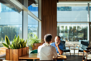 Two adults having worried conversation at hospital cafeteria
