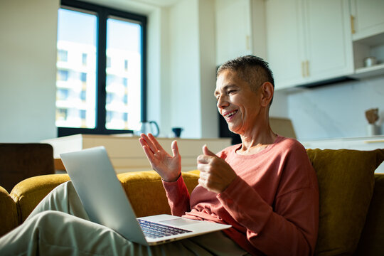 Mature adult smiling on video call at home