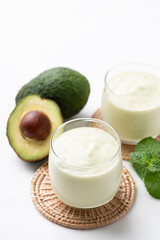 Avocado smoothie with milk in glass and avocado fruit on white background, Healthy drink