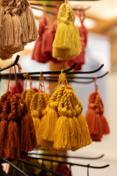 Orange and yellow colored tassel keychains at artisanal shop in Guatemala