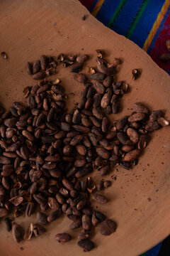cacao beans on traditional clay plate on traditional woven fabric