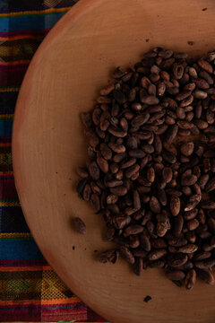 cacao beans on traditional clay plate on traditional woven fabric
