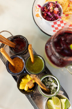 overhead shot of taco condiments - salsas, limes ,onion, cilantro, with sangria