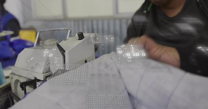 Worker guiding quilt under machine with ring, stitching lines, checking pattern in textile shop
