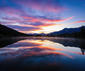 Lake Reflection of Mountain Sunset with Colorful Clouds for Scenic Landscape and Artistic Wallpaper