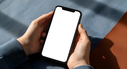 Close-up of hands holding a modern smartphone with a blank white screen.