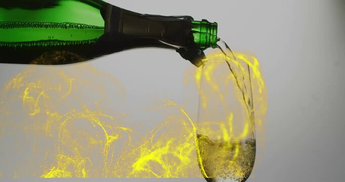 Tilting green bottle pouring pale champagne into flute, yellow swirls rising, filling glass