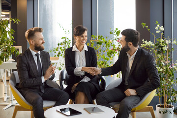 Businessman shaking hands with a coworker or client during a meeting in the office. Handshake represents a partnership, agreement, or deal, showcasing professionalism and collaboration in business.