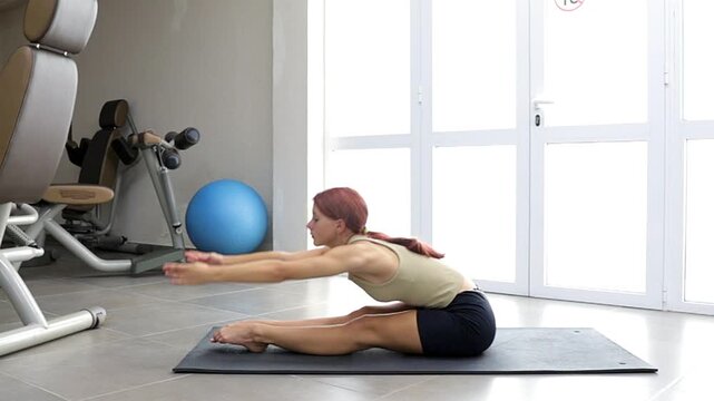 A fitness model performs a dynamic exercise routine to develop flexibility and balance. A female athlete demonstrates exercises