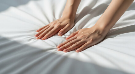 Hands spreading plain sheets in a bright bedroom, new‑life clean feel