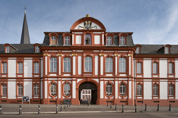 The richly decorated main facade of the Baroque Pr&auml;latur (Abbot's Palace) of Brauweiler Abbey, featuring the iconic red and white color scheme and the Romanesque church spire behind