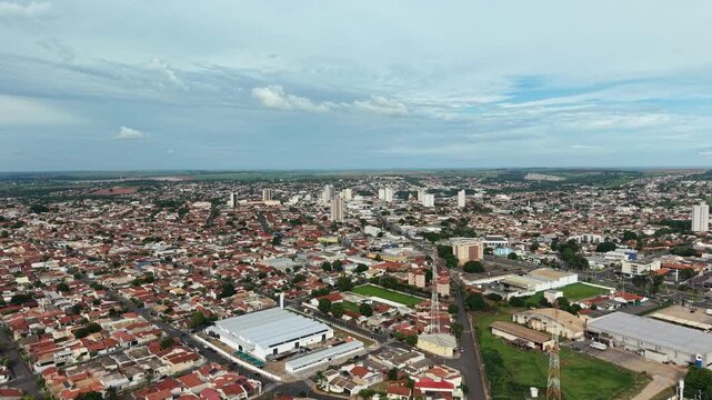 Aerial view captures urban landscape with buildings and houses under cloudy sky day