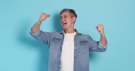 Excited man in stylish outfit on light blue background