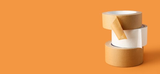 Rolls of masking tape on orange background with space for text