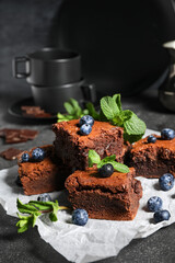 Pieces of tasty chocolate brownie on black background