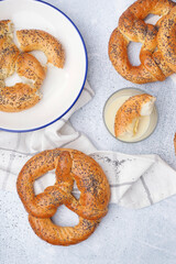 Tasty pretzels and condensed milk on light background