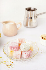Bowl with tasty Turkish delight on light background