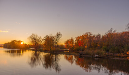 Colorful fall leaves with beatiful sunset on the lake
