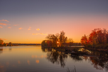 Fototapeta premium Colorful fall leaves with beatiful sunset on the lake