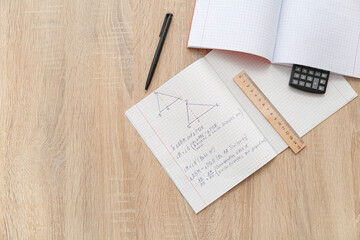 Obraz premium Open copybooks with math formulas, ruler and calculator on wooden table