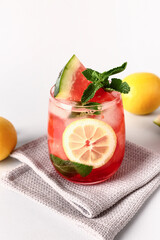Glass of fresh watermelon lemonade with mint on white background