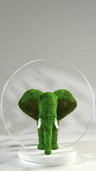 A creative topiary sculpture of a green moss elephant with white tusks, displayed on a modern white stand.