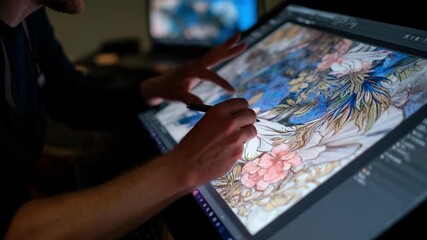 Closeup of a digital artist working with highdefinition images transferring detailed designs from a laptop to a professional display for quality inspection.