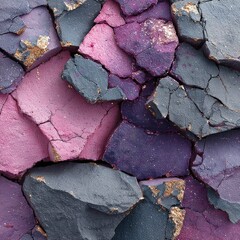 Close-up of cracked, multicolored stone with pink, purple, and gray hues