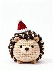 Handmade crochet hedgehog toy wearing a red Santa hat, isolated on white background, festive Christmas decoration