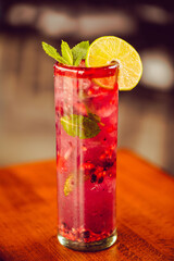 A berry mint mojito cocktail drink at a modern well lit Mexican food restaurant 