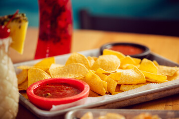 Chips and fresh salsa served with a beverage at a Mexican food restaurant