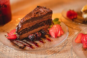 A slice of chocolate tort cake at a high end food restaurant with a strawberry garnish