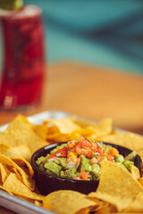Chips and fresh guacamole served with a beverage at a Mexican food restaurant 