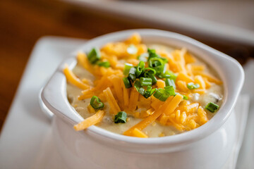 A cup of loaded baked potato soup at a bright modern food restaurant