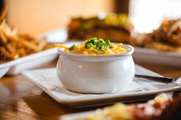 A cup of loaded baked potato soup at a bright modern food restaurant