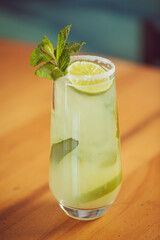 A mojito cocktail in a glass with mint garnish served at a brightly lit modern Mexican restaurant 