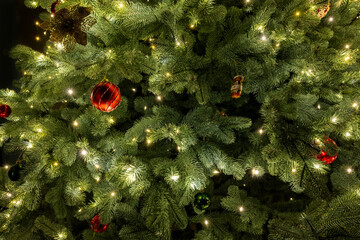 Close-up of a Christmas tree decorated with twinkling lights and colorful ornaments, creating a festive and joyful holiday mood.