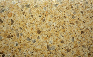 A close-up view of a brown marble mosaic with multicolored fine-grained inclusions.
