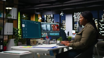 Black video creator working on editing a movie montage task, multitasking with dual monitors. Woman footage editor starting the creative process of video production, film industry. Camera A.