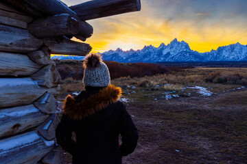 Girl looking at the sunset behind the Tetons from the J.P. Cunningham Cabin at Grand Teton National Park
