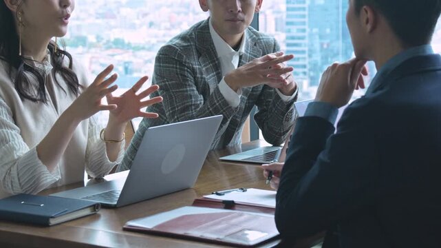 和やかな雰囲気でミーティングをする日本人男女	