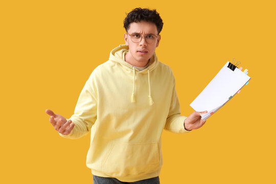 Male screenwriter with scenario on yellow background