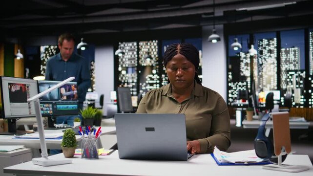 Diverse employees engaged in business intel and analytics using data diagrams in a corporate office, coworkers review projections and reports to improve overall company strategy. Camera A.