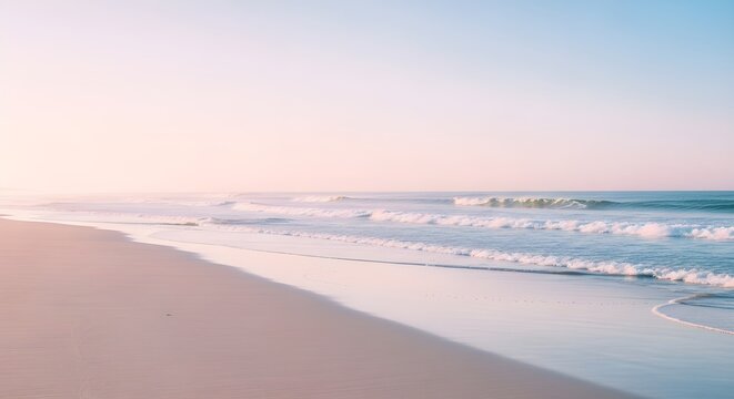 Soft pastel colored ocean waves gently washing onto a sandy beach at sunrise or sunset with a calm sea and sky - Powered by Adobe