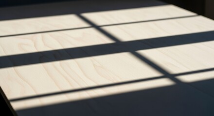 Lightcolored wooden surface with a grid of sharp shadows cast by sunlight through a window